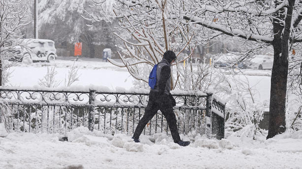 14.03.2024, USA, Denver: Ein Fußgänger geht den Speer Boulevard entlang, während ein später Wintersturm bis zu einem Meter Schnee fallen lässt. Vorhersagen zufolge wird der Sturm bis zum frühen Freitag andauern und den Verkehr entlang der Front Range von Colorado behindern. Foto: David Zalubowski/AP/dpa +++ dpa-Bildfunk +++
