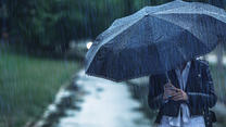 Frau mit Regenschirm trotzt dem Aprilwetter