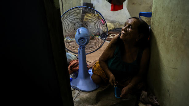 Suphan, 74, a blind woman uses a fan to cool down inside her room, as Thai authorities said that people had been killed by heatstroke this year and warned people to avoid outdoor activities, in Bangkok, Thailand, April 28, 2024. REUTERS/Athit Perawongmetha