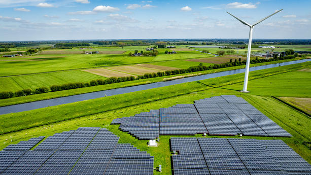 WAALWIJk - Drone photo of a solar park with solar panels and wind turbines from eneco are in the landscape in nature with electricity pylons in the foreground / 230424