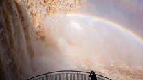A tourist takes a picture at Iguazu Falls, which are currently at full water capacity due to the rains in southern Brazil, at Iguazu Falls, Brazil, May 7, 2024. REUTERS/Kiko Sierich