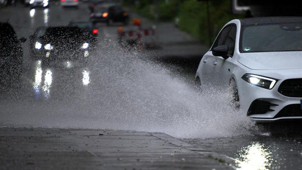 ARCHIV - 02.05.2024, Nordrhein-Westfalen, Köln: Ein Auto fährt durch eine große Wasserlache. (zu dpa: «Unwetter mit Starkregen in NRW erwartet») Foto: Federico Gambarini/dpa +++ dpa-Bildfunk +++