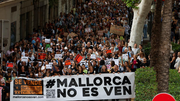 People hold a banner that reads Mallorca is not for sale, as they take part in a protest against mass tourism and gentrification in the island, ahead of summer season in Palma de Mallorca, Spain, May 25, 2024. REUTERS/Juan Medina