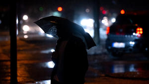 27.05.2024, Bayern, München: Ein Fußgänger geht mit einem Regenschirm in der Innenstadt im Regen über eine Kreuzung. Foto: Sven Hoppe/dpa +++ dpa-Bildfunk +++
