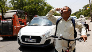 A man drinks a cooling drink offered by locals on a hot summer day during a heatwave in Narela, New Delhi, India, May 29, 2024. REUTERS/Priyanshu Singh