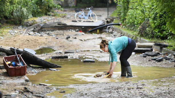 03.06.2024, Tschechien, Plzeò: Eine Frau steht in der Ortschaft Tìnovice auf einer Straße, die durch eine Überschwemmung zerstört worden ist. Foto: Chaloupka Miroslav/CTK/dpa +++ dpa-Bildfunk +++