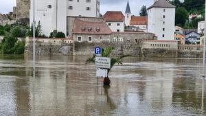 02.06.2024, Bayern, Passau: Ein Schild steht im Hochwasser. Die Drei-Flüsse-Stadt Passau in Niederbayern hat aufgrund des Starkregens ebenfalls mit erheblichem Hochwasser zu kämpfen. Der Pegelstand der Donau stieg am Sonntag auf mehr als 7,70 Meter, wie der Hochwassernachrichtendienst mitteilte. Zahlreiche Straßen und Plätze in Stadtgebiet stehen unter Wasser. Foto: Markus Zechbauer/Zema Medien/dpa +++ dpa-Bildfunk +++