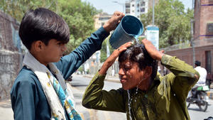 ARCHIV - 26.05.2024, Pakistan, Sukkur: Ein Junge wäscht sich den Kopf, um sich an einem heißen Sommertag abzukühlen. Wegen extrem hoher Temperaturen um die 50 Grad Celsius haben die Behörden Pakistans am Montag eine Hitzewarnung für Schwangere und ältere Menschen ausgesprochen. (zu dpa: «Leben bei 50 Grad: Wie halten Inder und Pakistaner diese Hitze aus?») Foto: Ppi/PPI via ZUMA Press Wire/dpa +++ dpa-Bildfunk +++