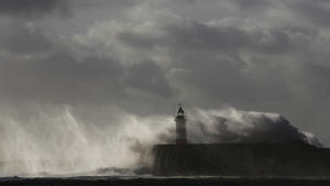Waves crash against a lighthouse during storms that battered Britain and where a 14-year-old boy was swept away to sea, at Newhaven in South East England October 28, 2013. Britain's strongest storm in a decade battered southern regions on Monday, forcing hundreds of flight cancellations, cutting power lines and disrupting the travel plans of millions of commuters. Police said rescuers were forced to call off a search for the boy late on Sunday due to the pounding waves, whipped up by the rising wind. REUTERS/Luke MacGregor (BRITAIN - Tags: ENVIRONMENT DISASTER)