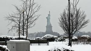 The Statue of Liberty is seen in the distance during the passing of a snowstorm at Liberty State Park in New Jersey, December 10, 2013. Fresh winter snow moved into the U.S. mid-Atlantic region on Tuesday, shutting schools and offices in the nation's capital and elsewhere as the mid-section of the country remained in the grip of Arctic air that showed no signs of easing. From 2 to 8 inches of snow was forecast to fall from northern Virginia, across Maryland, Pennsylvania, Delaware and into southern New England, Brian Korty, meteorologist with the National Weather Service (NWS) said in a forecast. REUTERS/Eduardo Munoz (UNITED STATES - Tags: ENVIRONMENT SOCIETY)