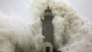epa04010451 A large wave strikes a lighthouse at the mouth of the River Douro, Porto, Portugal, 06 January 2014. The wave damaged some cars, as well as cuasing minor injuries to locals. EPA/ESTELA SILVA +++(c) dpa - Bildfunk+++