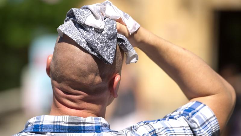ARCHIV - Ein Mann wischt sich am 02.08.2013 in Hannover (Niedersachsen) mit einem Stofftuch über den Kopf. 2013 sind alle denkbaren Wetterextrema aufgetaucht - ein Zusammenhang mit dem Klimawandel lässt sich nach Angaben der Meteorologen mit dem Wett