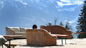 Eine Wanderin genießt am 21.03.2014 auf der Hochbichl-Hütte bei Ofterschwang (Bayern) auf einem Sofa sitzend den Sonnenschein und die Aussicht auf das Alpenpanorama. Foto: Karl-Josef Hildenbrand/dpa +++(c) dpa - Bildfunk+++