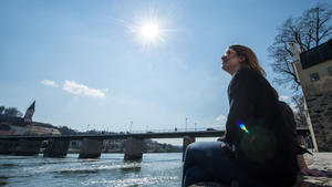 Studentin Denise sitzt am 27.03.2014 in Passau (Bayern) am Ufer der Inn und genießt die Sonne. Foto: Armin Weigel/dpa +++(c) dpa - Bildfunk+++