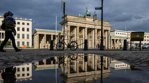 Das Brandenburger Tor spiegelt am 13.05.2014 in Berlin in einer Regenpfütze. Das Wetter zeigt sich eher unbeständig. Und das soll auch noch anhalten. Foto: Paul Zinken/dpa +++(c) dpa - Bildfunk+++