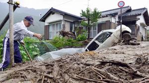 A man clears debris at an area affected by landslide caused by heavy rains due to Typhoon Neoguri in Nagiso town, Nagano prefecture, in this photo taken by Kyodo July 10, 2014. A landslide pummelled the town of Nagiso in central Japan late on Wednesday, sending a cascade of mud and boulders through the streets and killing a 12-year-old boy, bringing the death toll from the storm to three. Mandatory credit. REUTERS/Kyodo (JAPAN - Tags: ENVIRONMENT DISASTER) ATTENTION EDITORS - FOR EDITORIAL USE ONLY. NOT FOR SALE FOR MARKETING OR ADVERTISING CAMPAIGNS. THIS IMAGE HAS BEEN SUPPLIED BY A THIRD PARTY. IT IS DISTRIBUTED, EXACTLY AS RECEIVED BY REUTERS, AS A SERVICE TO CLIENTS. MANDATORY CREDIT. JAPAN OUT. NO COMMERCIAL OR EDITORIAL SALES IN JAPAN. YES