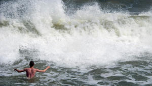 Große Wellen schlagen am 09.07.2014 an den Ostseestrand des Seebades Zinnowitz auf der Insel Usedom (Mecklenburg-Vorpommern). Touristen suchen in der der Gischt des Meeres eine Abkühlung. Foto: Stefan Sauer/dpa +++(c) dpa - Bildfunk+++