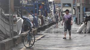 Fishermen in raincoats walk past fishing boats as Typhoon Matmo approaches the northeastern coastal town of Nanfangao in Ilan county, northern Taiwan, July 22, 2014. REUTERS/Pichi Chuang (TAIWAN - Tags: ENVIRONMENT)