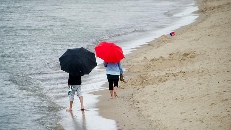 Touristen laufen im Regen am 20.08.2014 am Strand des Seebades Zinnowitz auf der Insel Usedom (Mecklenburg-Vorpommern). Die Meteorologen erwarten auch in den kommenden Tagen wechselhaftes Wetter an der Ostsee. Foto: Stefan Sauer/dpa +++(c) dpa - Bildfunk+++