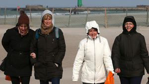 Warm eingepackt sind Spaziergänger am 08.03.2013 am Ostseestrand von Warnemünde (Mecklenburg-Vorpommern) unterwegs bei starkem Wind. In den kommenden Tagen wird sich der Winter mit Frost und Schnee in weiten Teilen Deutschlands zurückmelden. Foto: Bernd Wüstneck/dpa +++(c) dpa - Bildfunk+++