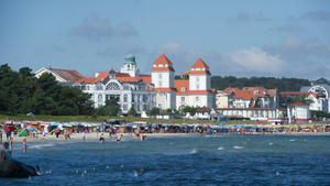 Badegäste sind am 28.08.2014 am Strand von Binz (Mecklenburg-Vorpommern) vor dem Kurhaus (M) auf der Ostseeinsel Rügen unterwegs. Foto: Stefan Sauer/dpa +++(c) dpa - Bildfunk+++
