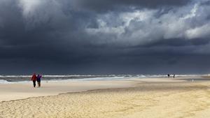 dunkle Regenwolken ueber Spaziergaenger am Sandstrand, Deutschland, Schleswig-Holstein, Sylt | dark rain clouds over pedestrians on sandy beach, Germany, Schleswig-Holstein, Sylt