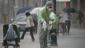 epa04434165 A cleaning worker is on duty during heavy rain in Tokyo, Japan, 06 October 2014 as Typhoon Phanfone is approaching the Japanese capital. Typhoon Phanfone battered Tokyo, disrupting transport, after lashing western and southern Japan, leaving two dead and three missing. More than two million people were advised to evacuate their homes with the Japan Meteorological Agency warning of mudslides, heavy rains, swollen rivers and strong winds in wide areas of the country. EPA/KIMIMASA MAYAMA +++(c) dpa - Bildfunk+++