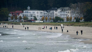 Touristen spazieren am 18.10.2014 am Strand des Ostseebades Binz auf der Insel Rügen (Mecklenburg-Vorpommern) entlang. Foto: Stefan Sauer/dpa +++(c) dpa - Bildfunk+++