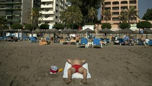 A man sunbathes on a hot autumn day at La Banjandilla beach in Marbella, near Malaga, southern Spain, October 21, 2014. REUTERS/Jon Nazca (SPAIN - Tags: ENVIRONMENT SOCIETY TRAVEL)