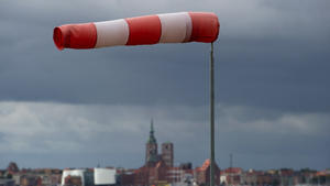 Ein Windsack steht fast horizontal in der Luft und zeigt somit recht starken Wind an, aufgenommen am 22.09.2014 in Altefähr (Mecklenburg-Vorpommern) an der Rügenbrücke auf der Insel Rügen, im Hintdergrund die Silhouette der Hansestadt Stralsund. Foto: Stefan Sauer/dpa +++(c) dpa - Bildfunk+++