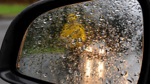 Ein Radfahrer mit gelbem Ölzeug im Scheinwerferlicht eines Autos spiegelt sich am 19.12.2014 im regennassen Rückspiegel eines parkenden Fahrzeugs in Oldenburg (Niedersachsen). Temperaturen um elf Grad Celsius und Dauerregen bestimmen zur Zeit das Wetter in Norddeutschland. Foto: Ingo Wagner/dpa +++(c) dpa - Bildfunk+++
