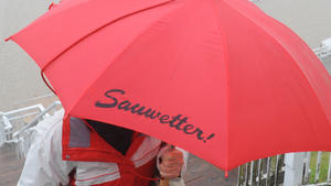 Illustration - Eine Frau läuft am Mittwoch (19.05.2010) mit einem Regenschirm mit dem kleinen Aufdruck "Sauwetter" über die Seebrücke am Strand des Seebades Sellin auf der Insel Rügen. Ein Wechsel aus Regen, Nebel und Wolken bestimmt das Wetter vor dem Pfingstwochenende an der Ostsee. Foto: Stefan Sauer dpa/lmv  +++(c) dpa - Bildfunk+++