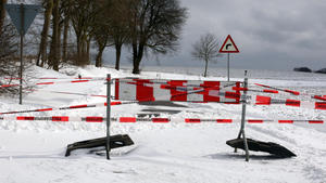 Eine wegen Schneeverwehungen von der Polizei gesperrte Straße ist am 11.03.2013 in der Nähe von Sütel (Schleswig-Holstein) zu sehen. Nach kräftigen Schneefällen kam es im Norden zu zahlreichen Unfällen auf teilweise vereisten und blockierten Straßen. Foto: Daniela Nyfeler/dpa +++(c) dpa - Bildfunk+++