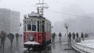 epa04623737 People walk near a tram under a heavy snow near Gezi Park on Taksim Square during a snowy day in Istanbul, Turkey, 17 February 2015. Due to the winterly weather conditions in Istanbul, some flights from the city's airport had to be cancelled. EPA/SEDAT SUNA +++(c) dpa - Bildfunk+++