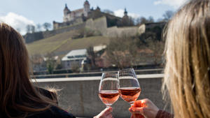 Zwei Frauen trinken am 11.03.2015 vor der Kulisse der Festung Marienberg in Würzburg (Bayern) ein Glas Wein. Foto: Daniel Karmann/dpa +++(c) dpa - Bildfunk+++