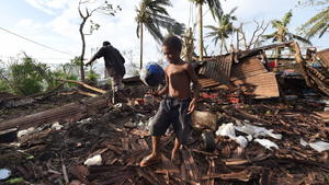 dpatopbilder epa04664493 Samuel plays with a ball found in the ruins while his father Phillip searches in what remained of their family home in Port Villa, capital of Vanuatu, 16 March 2015. International relief work was under way 16 March in Vanuatu and Tuvalu, impoverished island nations ravaged by the worst tropical cyclone on record in the South Pacific with aid agencies saying conditions in cyclone-ravaged Vanuatu are among the most challenging they have faced. Tropical Cyclone Pam left a trail of destruction when it ripped through the region at the start of the weekend with winds in excess of 250 kilometres per hour, heavy downpours and flooding. EPA/DAVE HUNT AUSTRALIA AND NEW ZEALAND OUT (zu dpa "Vanuatu räumt nach Zyklon «Pam» auf - Sorge um tiefliegende Inseln" am 16.03.2015) +++(c) dpa - Bildfunk+++