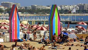 Zahlreiche Menschen bevölkern am 13.5.2002 den Strand am Palmenboulevard La Croisette in Cannes. Woody Allens Komödie «Hollywood Endings» eröffnet am 15.5. die  55. Internationalen Filmfestspiele. Mit insgesamt mehr als 11000 professionellen Teilnehmern beim Festival und dem zeitgleich laufenden Filmmarkt wird die französische Stadt an der Cote d'Azur wieder für zwölf Tage zum weltweit wichtigsten und glamourösesten Treffpunkt der Filmbranche. Um die Goldene Palme, die am Sonntag, 26. Mai, verliehen wird, konkurrieren dieses Jahr 22 Produktionen aus 15 Ländern. Ein deutscher Beitrag ist zum neunten Mal in Folge nicht dabei.