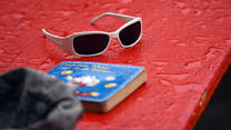 Eine vom Regen nasse Kindersonnenbrille und ein Kinderbuch liegen am 19.06.2015 in einem Biergarten im Blücherpark in Köln (Nordrhein-Westfalen) auf einem Tisch. Auch zum kalendarischen Sommmeranfang am 21.06.2015 soll das Wetter kühl und regnerisch bleiben. Foto: Henning Kaiser/dpa +++(c) dpa - Bildfunk+++