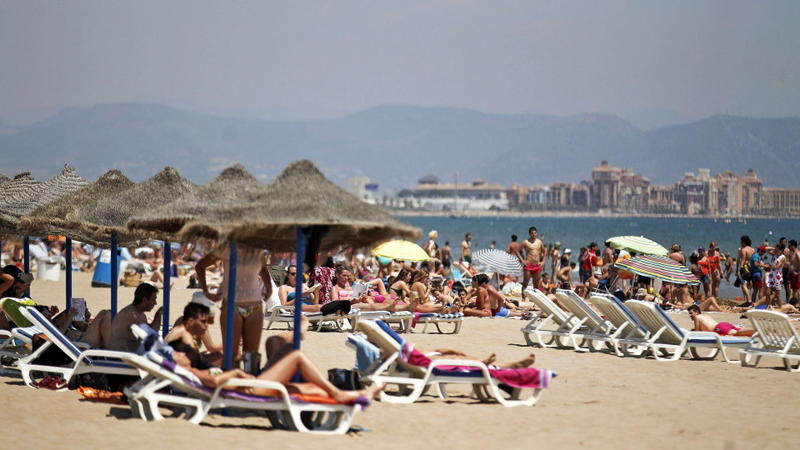 epa04819878 Tourists sunbathe on the beach of La Malvarrosa and Arenas in Valencia, Spain, 26 June 2015. The Spanish National Meteorology Agency (AEMET) announced a progessive increase of the temperatures set to reach 40 degrees during the day and over 20 degrees at night in several parts of the country. EPA/MANUEL BRUQUE +++(c) dpa - Bildfunk+++