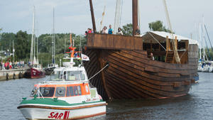 Ein Seenotrettungsboot schleppt am 27.08.2015 die historische Pommernkogge "Ucra" vom Yachthafen am Stettiner Haff zum endgültigen Liegplatz im Stadthafen von Ueckermünde (Mecklenburg-Vorpommern). Die 26 Meter lange Kogge wurde nach dem Vorbild eines Schiffsmodells (um 1450) aus der Stiftskirche Chemnitz-Ebersdorf (Sachsen) gefertigt. Am Fachbereich Maschinenbau und Schiffstechnik der Universität Rostock wurden das Schiffsmodell vermessen, Konstruktionsunterlagen erstellt sowie Modelle im Wind- und Strömungskanal getestet. Das Schiff soll nach der Taufe im Oktober 2015 Touristen und Schifffahrtsbegeisterten für Ausfahrten auf dem Stettiner Haff und der Ostsee zur Verfügung stehen. Foto: Stefan Sauer/dpa +++(c) dpa - Bildfunk+++