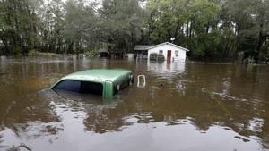A vehicle and a home are swamped with floodwater from nearby Black Creek in Florence, S.C., Monday, Oct. 5, 2015 as flooding continues throughout the state following several days of rain. (AP Photo/Gerry Broome)