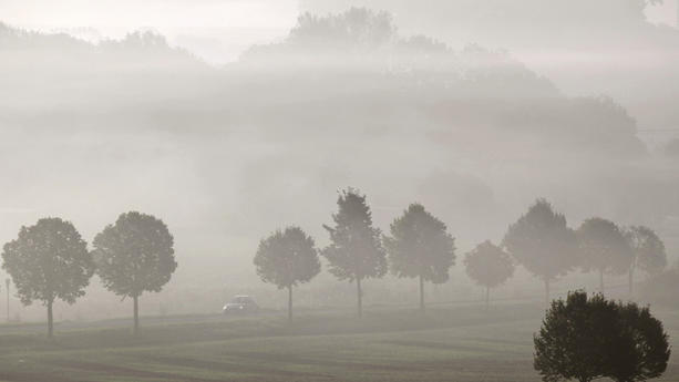 Ein Auto fährt durch morgendlichen Nebel am Mittwoch (06.10.2010) über eine Landstraße bei Freyburg (Unstrut). Die Meteorologen sagen auch für die nächsten Tage sonniges Oktoberwetter voraus. Foto: Jan Woitas dpa/lah  +++(c) dpa - Bildfunk+++