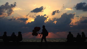 epa05017587 A picture made available on 09 November 2015 shows a Palestinian man (C) selling balloons as people enjoy the sunset next to the beach of Gaza City, Gaza Strip, 08 November 2015. EPA/MOHAMMED SABER +++(c) dpa - Bildfunk+++
