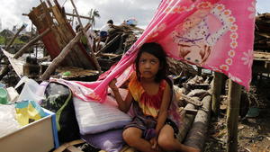 epa05070628 A Filipino girl rests next to a damaged house in the typhoon-hit town of Magallanes, Sorsogon province, southern Manila, Philippines, 16 December 2015. At least four people were killed and hundreds of thousands were displaced as a powerful typhoon pummelled the Philippines for the second day, officials said. Typhoon Melor also toppled trees and electric posts, totally and partially destroyed houses, as well as rice paddies submerged in waters, according to the National Disaster Risk Reduction and Management Council (NDRRMC). Thousands of air and sea passengers were stranded in different ports and airports as 64 domestic flights were cancelled while hundreds of ships stopped from sailing due to bad weather. EPA/FRANCIS R. MALASIG +++(c) dpa - Bildfunk+++