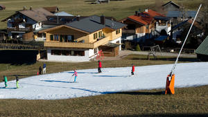 Skifahrer nutzen in Garmisch-Partenkirchen (Bayern) am Hausberg einen schmalen Kunstschneeteppich. Foto: Angelika Warmuth/dpa (zu dpa «Es wird kälter in Bayern: noch kein Wintereinbruch in Sicht» vom 28.12.2015) +++(c) dpa - Bildfunk+++