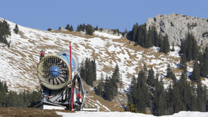 ARCHIV - Eine Schneekanone steht am 03.12.2015 einsatzbereit im Skigebiet Sudelfeld bei Bayrischzell (Bayern). Die milden Temperaturen über Null Grad verhinderten noch einen regelmässigen Betrieb der Maschinen zur Erzeugung von Kunstschnee, auch Naturschnee gab es zum Beginn der Skisaison in Bayern kaum. Foto: Uwe Lein/dpa (Zu dpa "Winter nicht mehr weiß - Satellitenbild zeigt viele schneefreie Tage" vom 23.02.2016) +++(c) dpa - Bildfunk+++