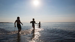 Drei Jugendliche gehen am 06.05.2016 am Strand von Rerik (Mecklenburg-Vorpommern) für ein kurzes Bad in die Ostsee. Lufttemperaturen über 20 Grad lockten einige Mutige in das rund zehn  Grad kalte Wasser der Ostsee. Foto: Christian Charisius/dpa +++(c) dpa - Bildfunk+++