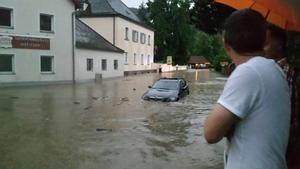 Nach schweren Unwettern mit Starkregen stehen zwei Männer in Grafenau im Landkreis Passau (Bayern) am 25.06.2016 in einer überschwemmten Straße. ACHTUNG: Bestmögliche Qualität. Foto: Norbert Pree/dpa +++(c) dpa - Bildfunk+++