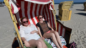 Die Studentinnen Michaela und Louisa (l-r) aus Lübeck liegen bei strahlendem Sonnenschein am 15.04.2015 am Ostseestrand von Travemünde (Schleswig-Holstein) im Strandkorb. Foto: Carsten Rehder/dpa | Verwendung weltweit