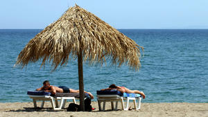 Zwei Urlauber am Strand an der Südküste der griechischen Insel Samos, aufgenommen am 31.05.2005. Die Insel Samos, die zu den grünsten Inseln in der Ägäis gehört, liegt nur 1300 Meter vor der türkischen Küste. Sie ist 45 Kilometer lang und 20 Kilometer breit und hat rund 31.000 Einwohner. Foto: Peter Zimmermann +++(c) dpa - Report+++